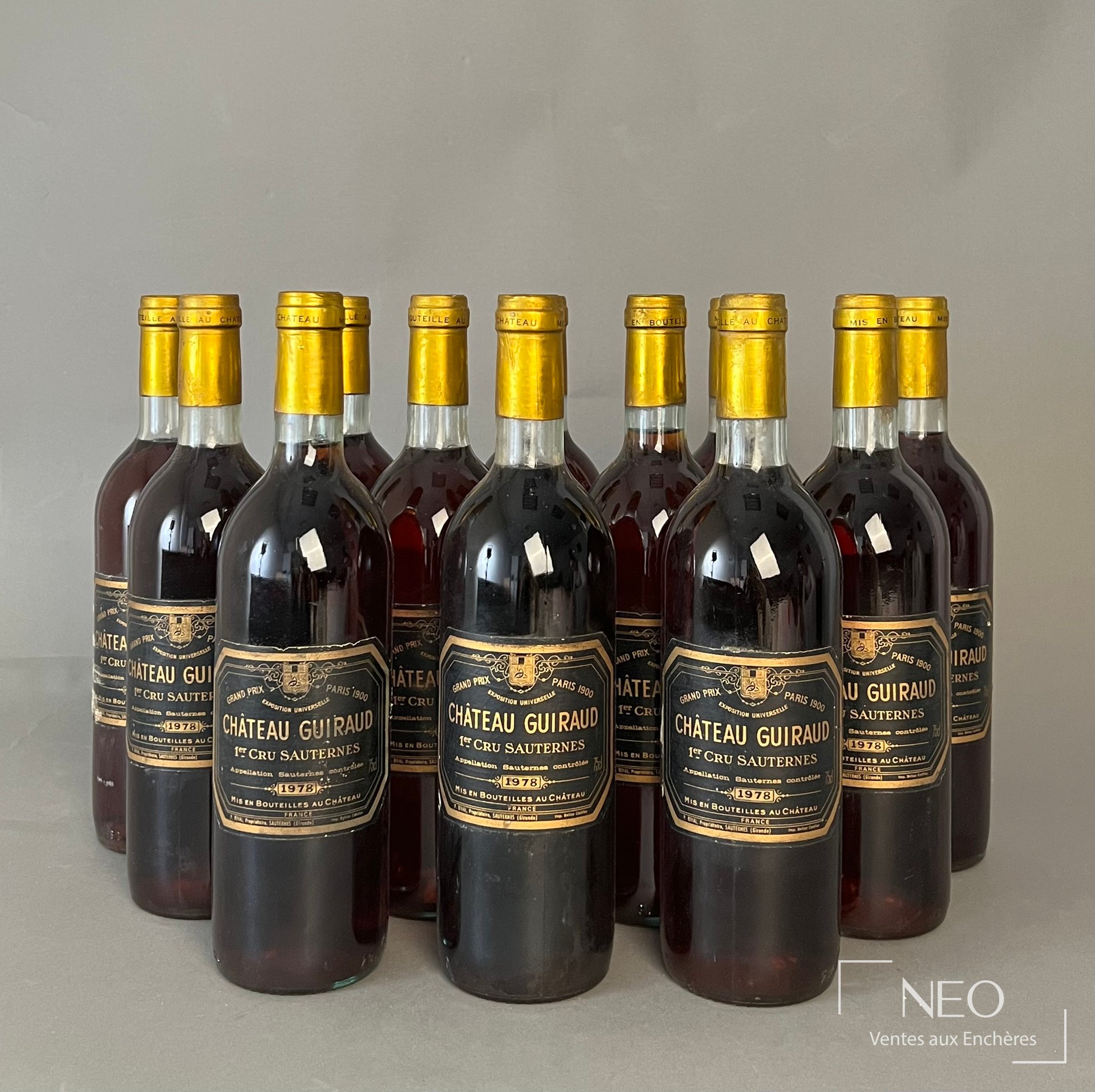 Douze bouteilles de Château Guiraud 1978 alignées