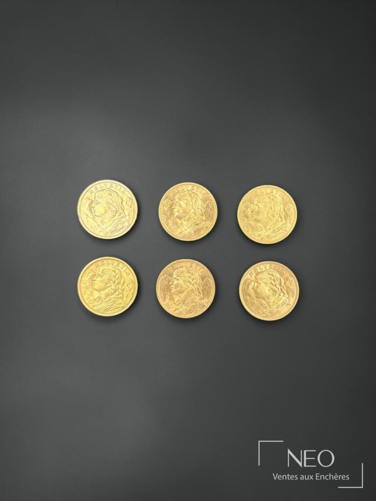 Six pièces de 20 francs or Helvetia disposées sur fond gris