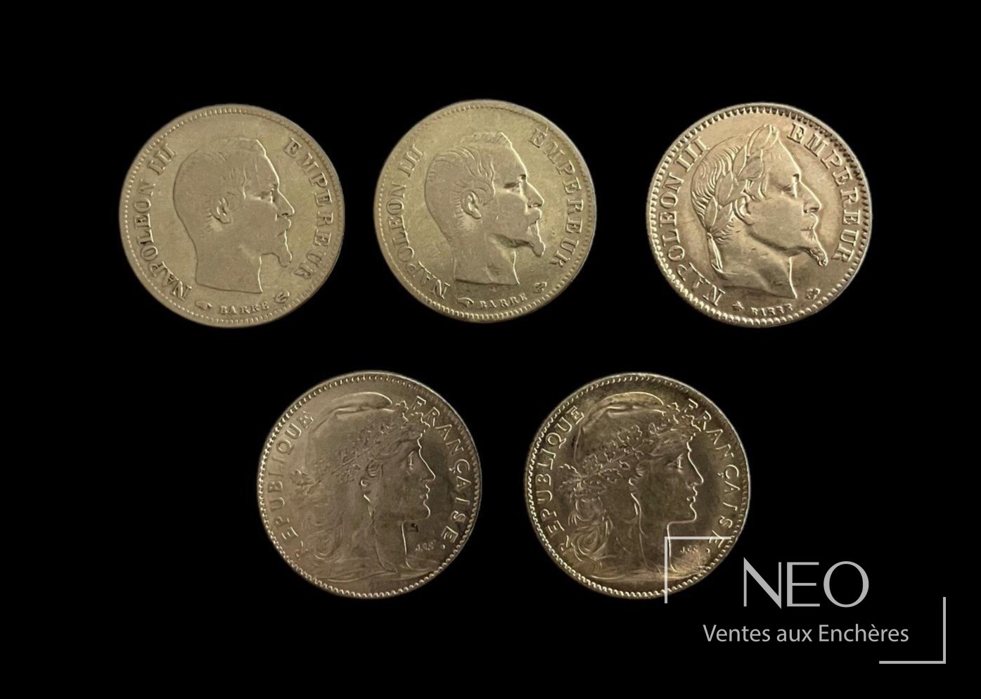 Cinq pièces de 10 francs or présentées sur fond noir
