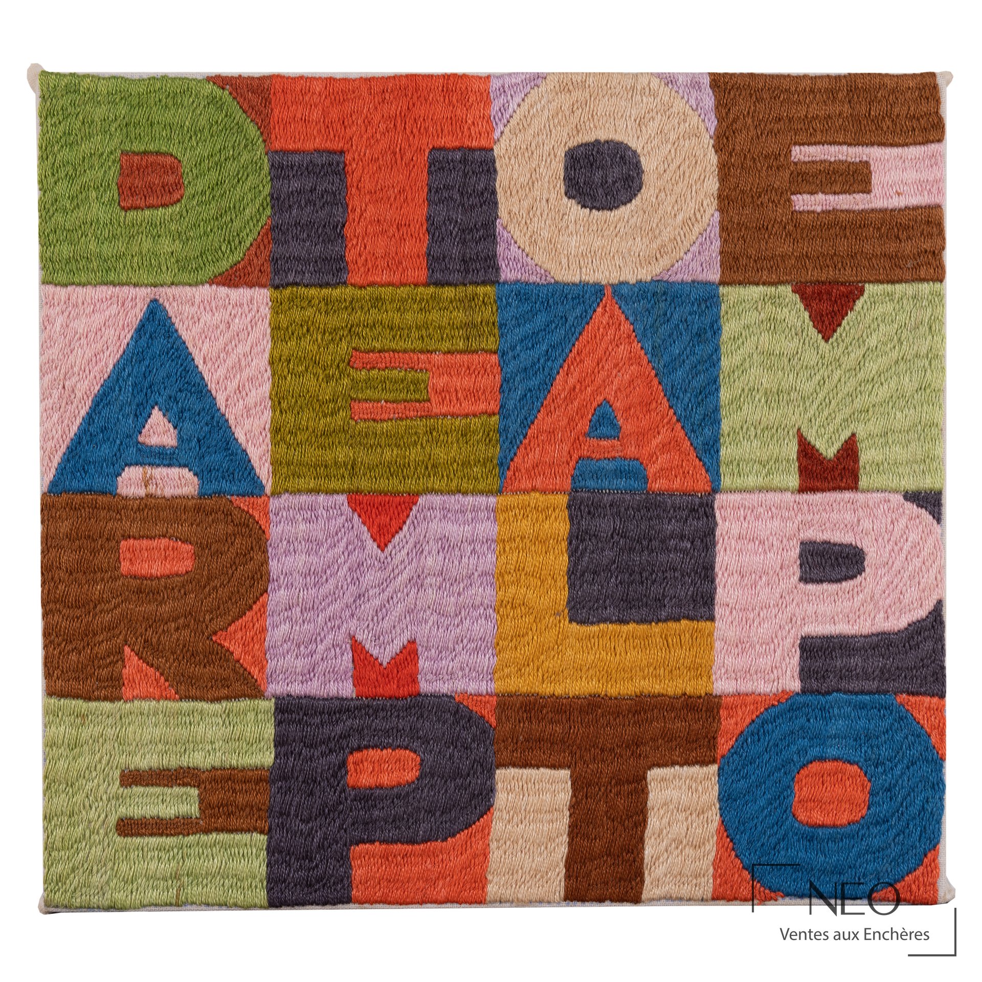 Broderie colorée formant des lettres sur fond quadrillé