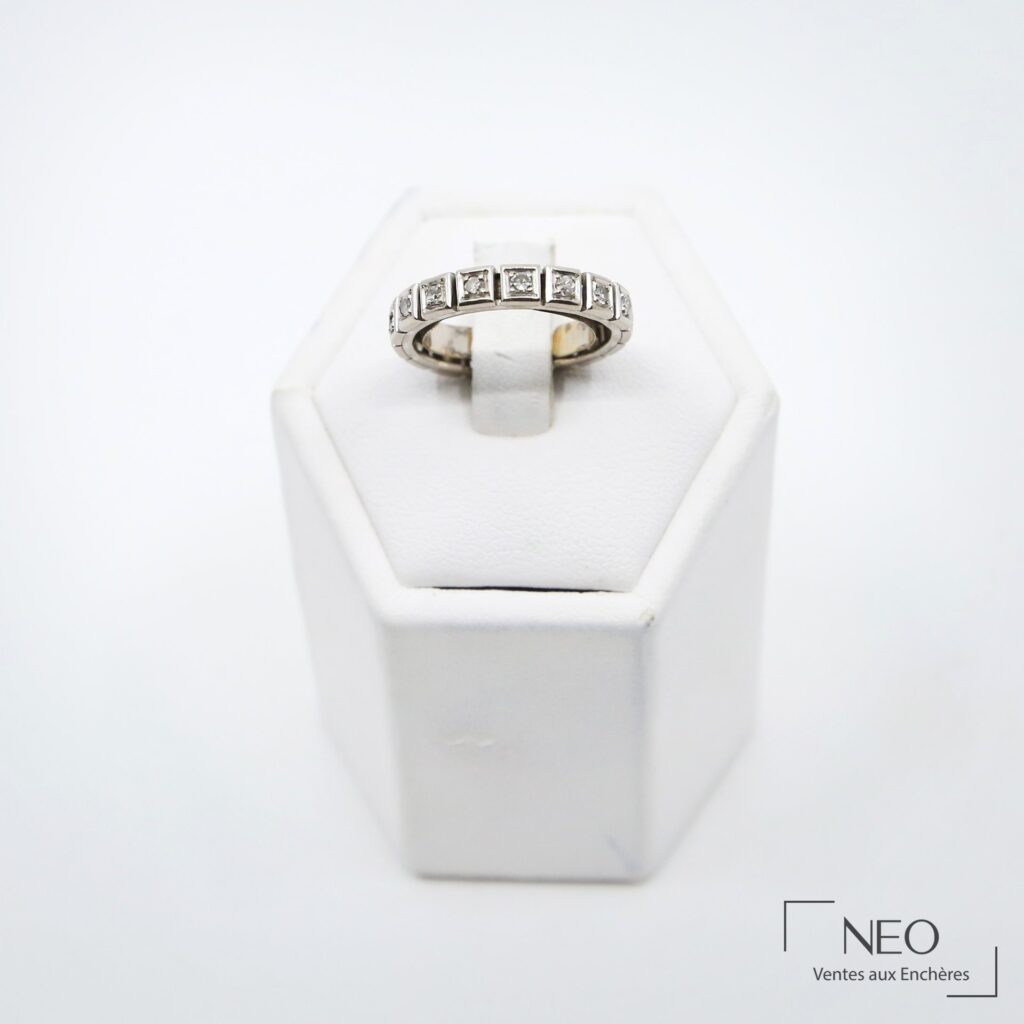 Alliance en or gris sertie de diamants présentée de face sur son support blanc