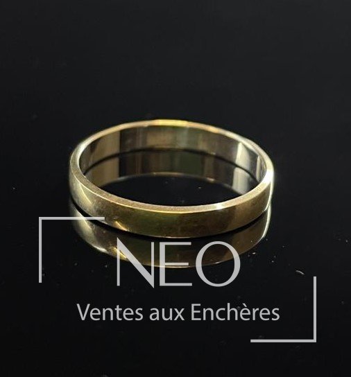Alliance en or gris posée sur fond noir