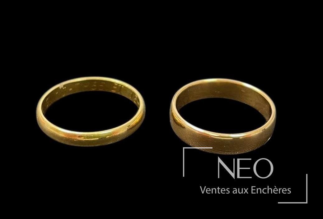 Deux alliances en or jaune vues de face sur fond noir