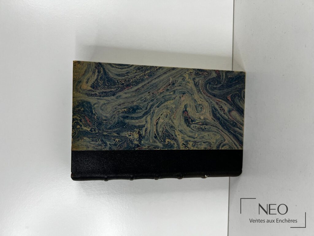 Couverture marbrée et bas de reliure noire d'un livre ancien