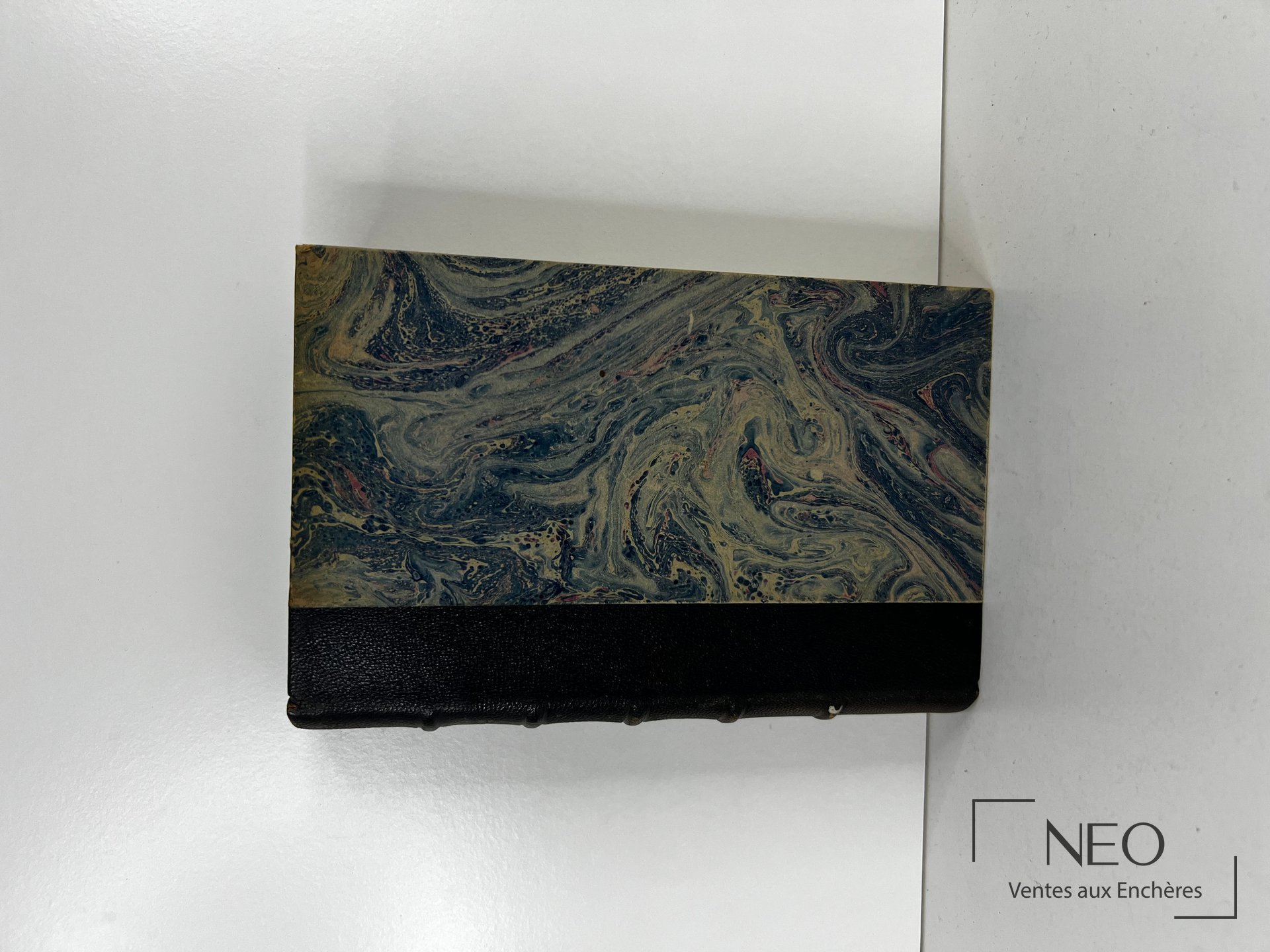 Couverture marbrée et bas de reliure noire d'un livre ancien