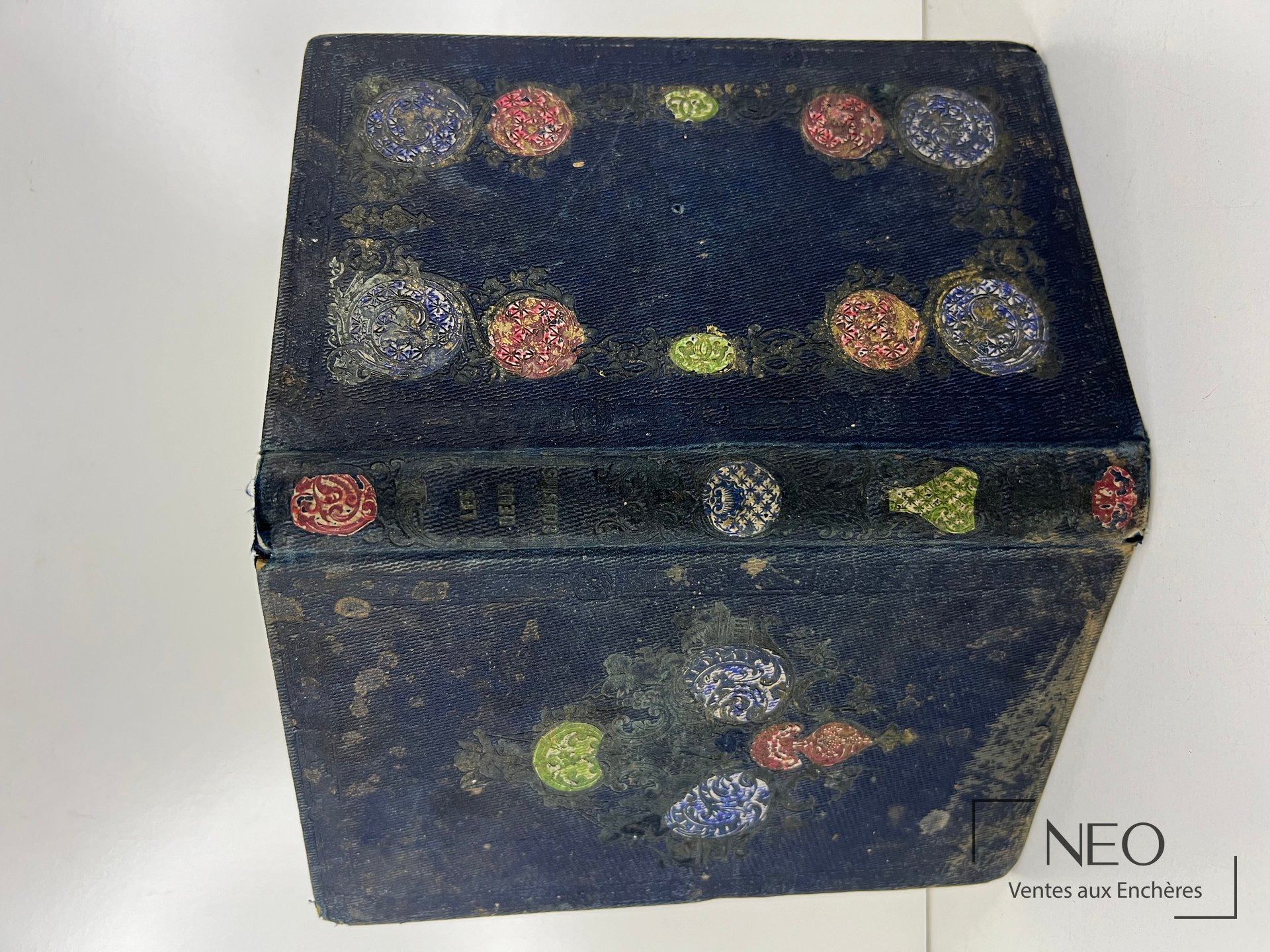 Couverture bleue ornée de motifs circulaires polychromes et d’usures visibles