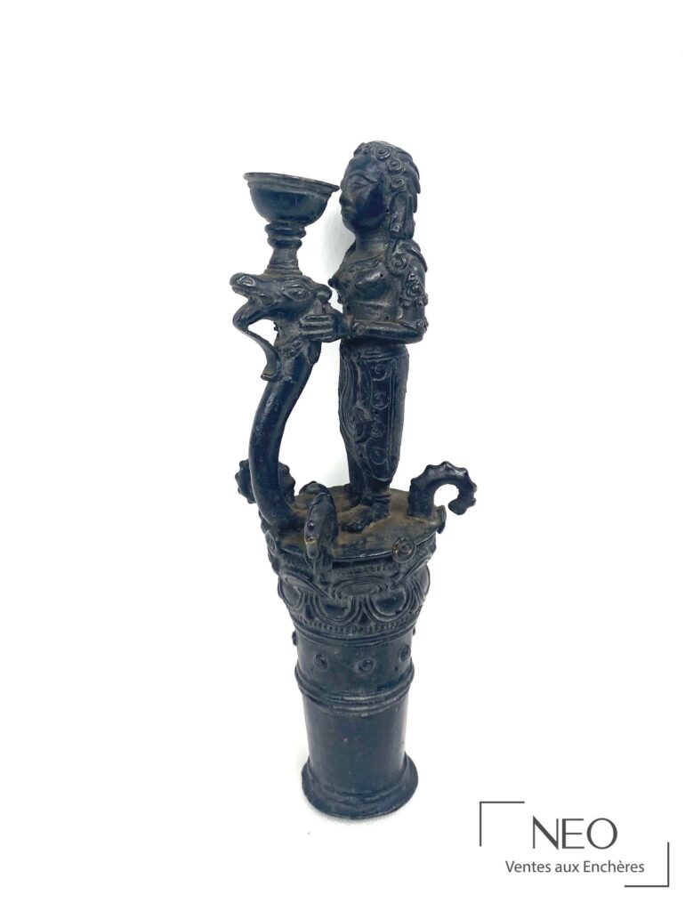 Petite figure en bronze à patine brune tenant une coupe surmontée d'une tête d'animal