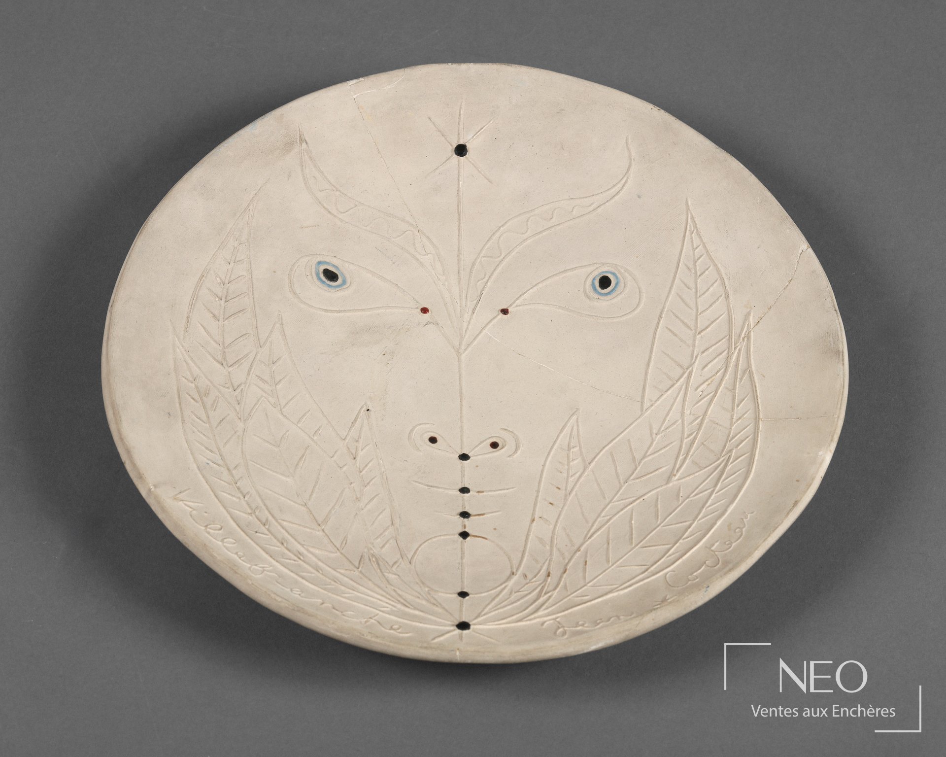 Assiette circulaire de Jean Cocteau avec motif de visage stylisé en émail noir