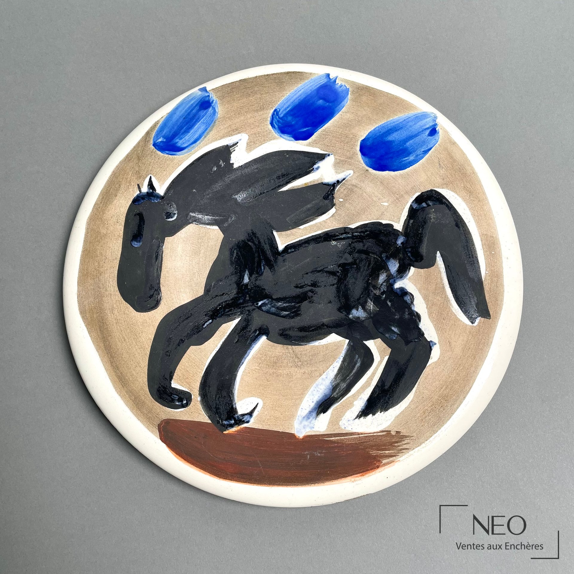 Assiette ronde de Pablo Picasso au décor polychrome représentant un cheval noir sur fond ocre