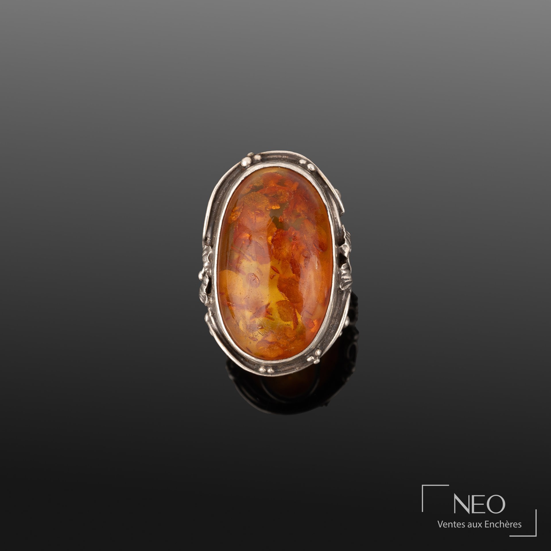 Bague en argent avec cabochon d'ambre ovale et décor feuillagé