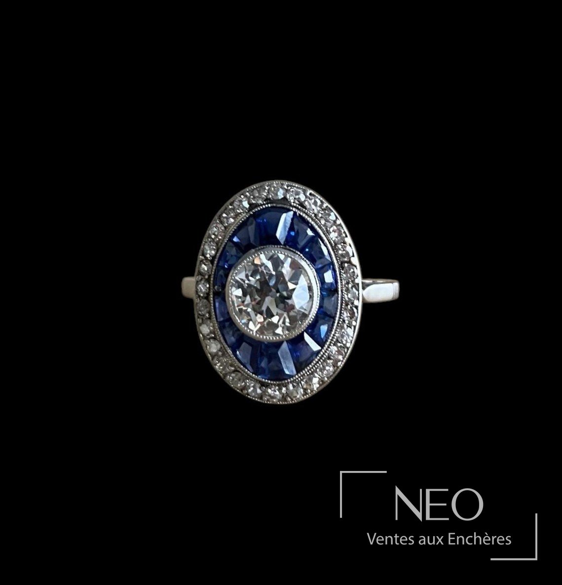 Bague Belle Epoque en platine avec diamant central et entourage de saphirs bleus