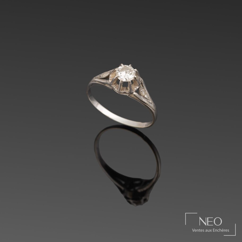 Bague en or gris avec diamant central et monture ajourée