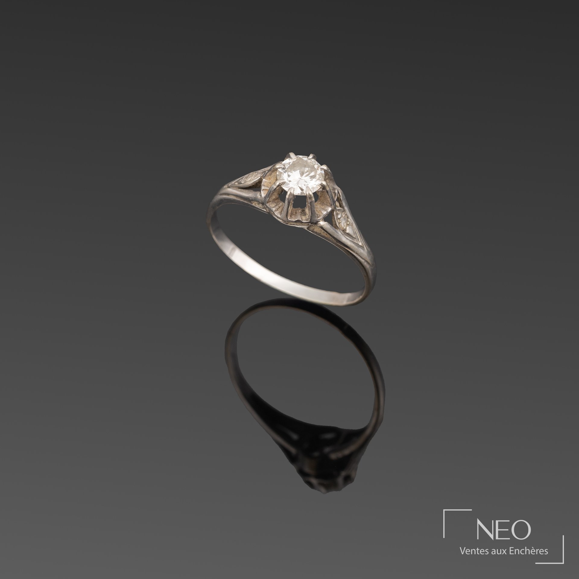 Bague en or gris avec diamant central et monture ajourée