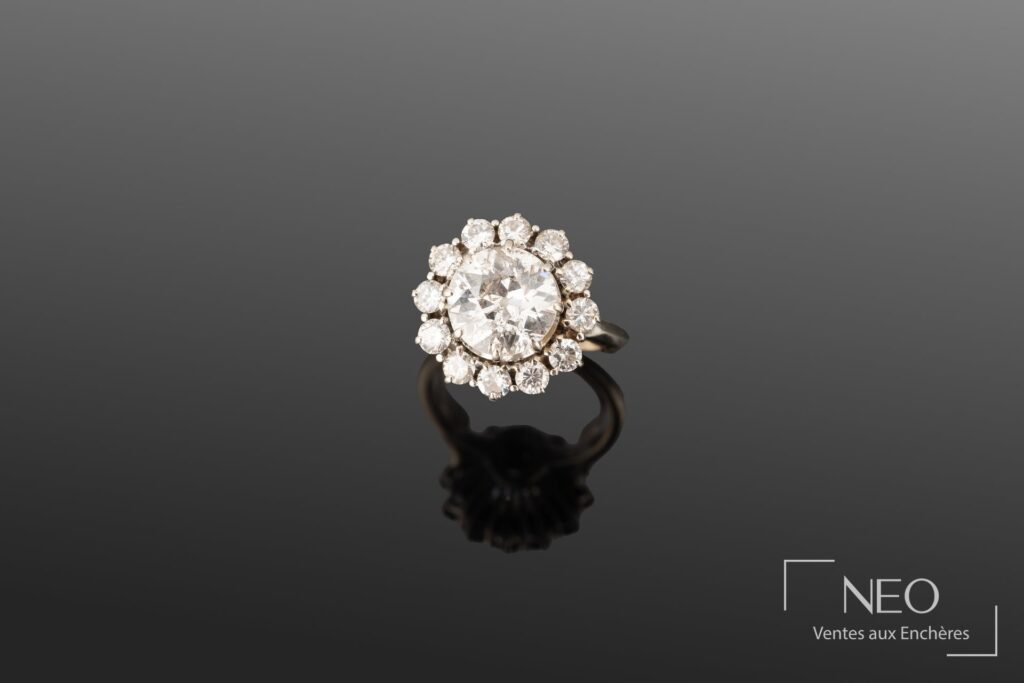 Bague en or gris sertie d’un diamant central entouré de diamants