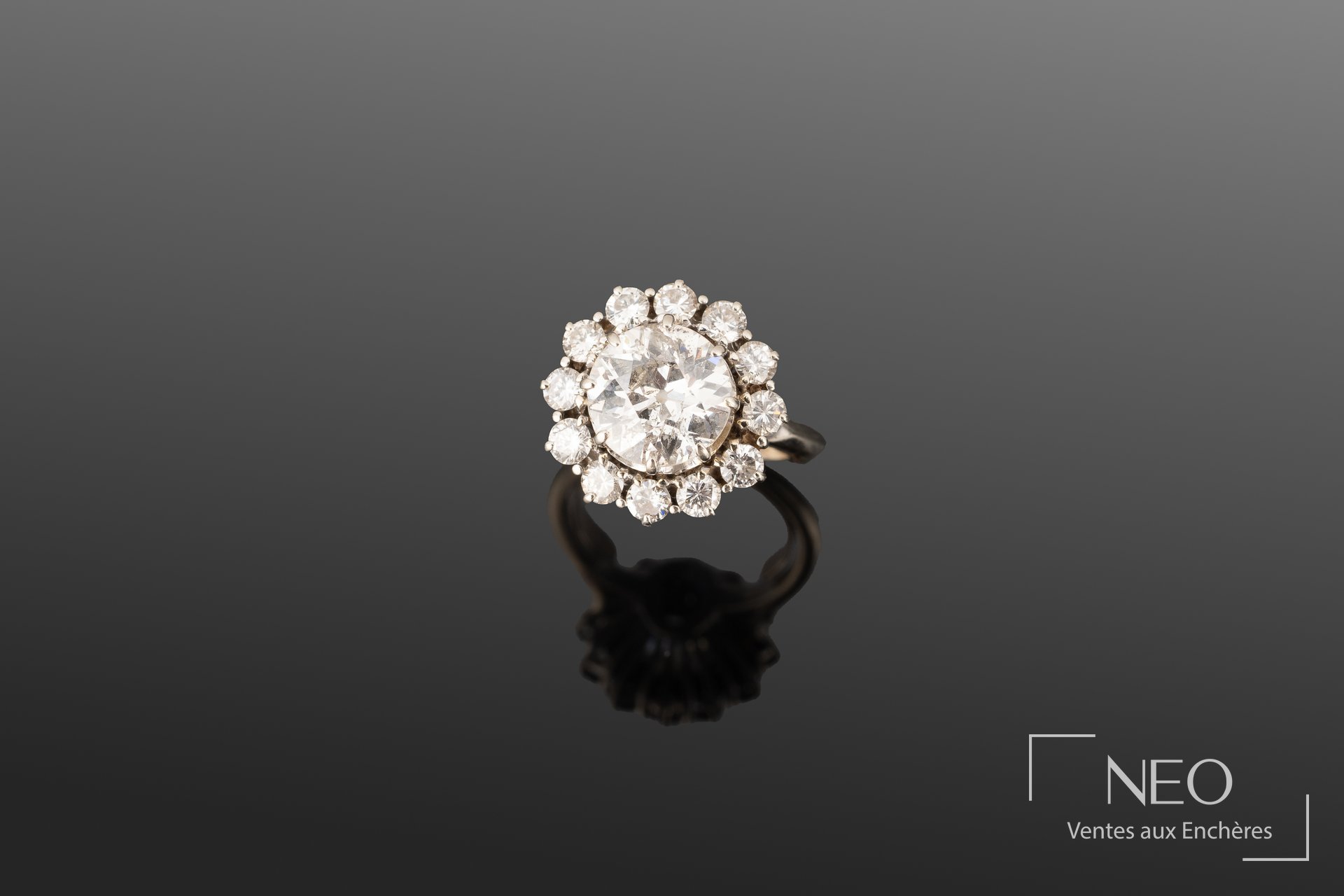 Bague en or gris sertie d’un diamant central entouré de diamants