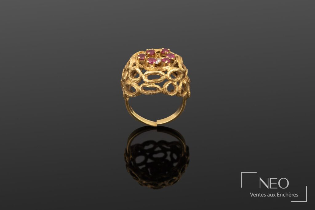 Bague en or jaune ajourée sertie d'un diamant entouré de rubis