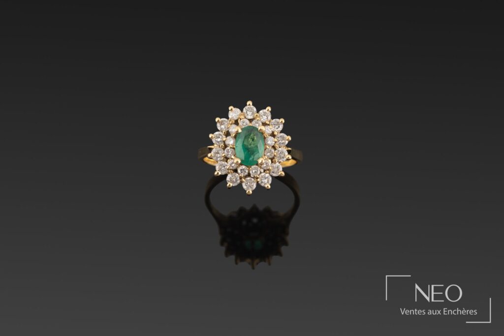 Bague en or jaune avec émeraude ovale au centre et double entourage de brillants