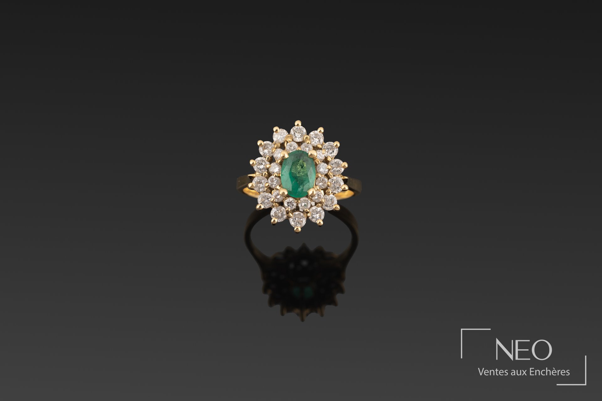 Bague en or jaune avec émeraude ovale au centre et double entourage de brillants
