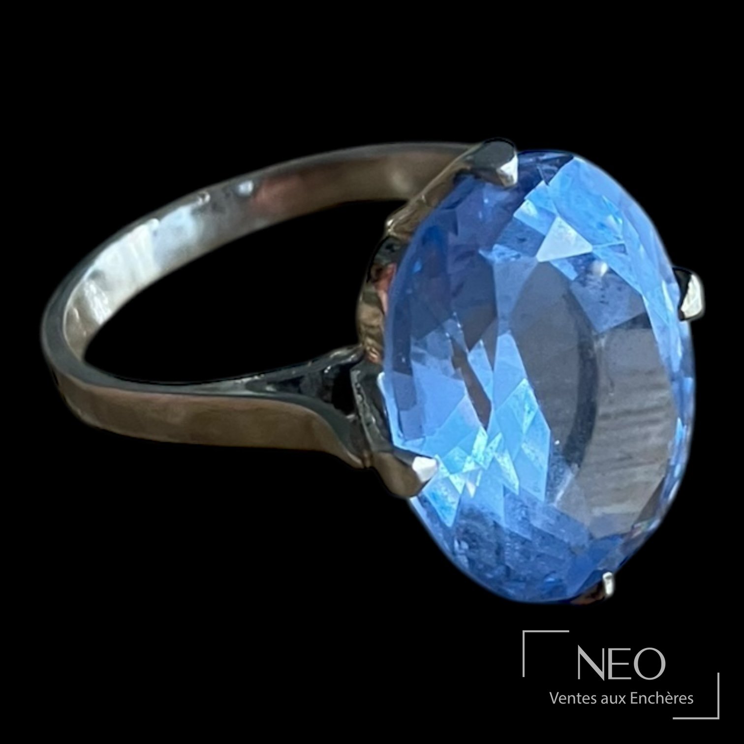 Bague en or gris sertie d'une pierre bleue ovale