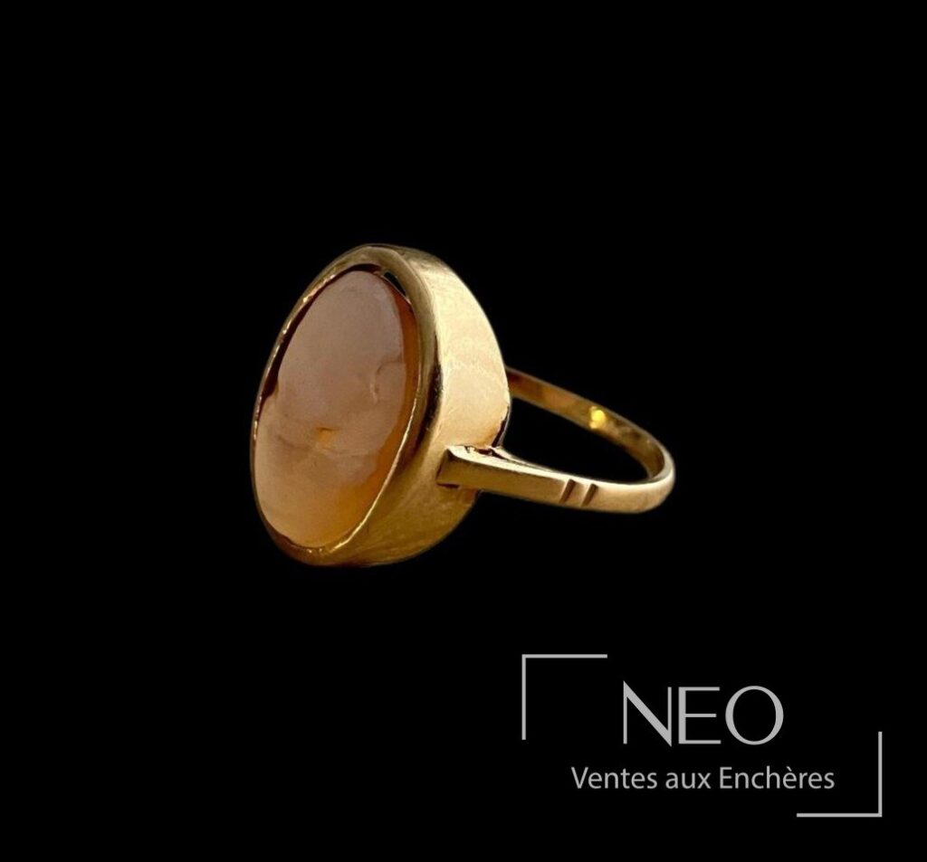 Bague en or jaune avec camée ovale vue de trois quarts sur fond noir