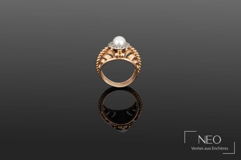 Bague en or jaune avec perle de culture blanche et entourage ajouré