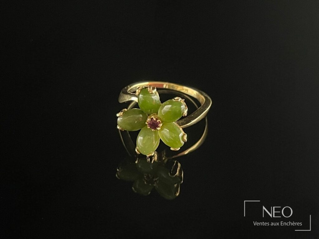 Bague fleur en or jaune avec pierre rouge centrale et pétales en pierres vertes