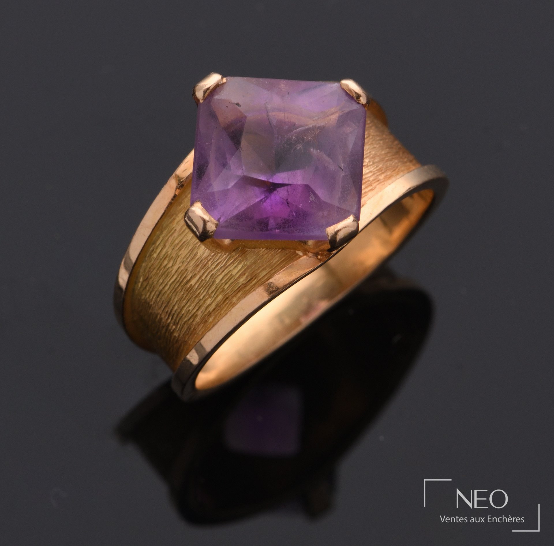 Bague jonc en or 18 carats sertie d’une pierre violette