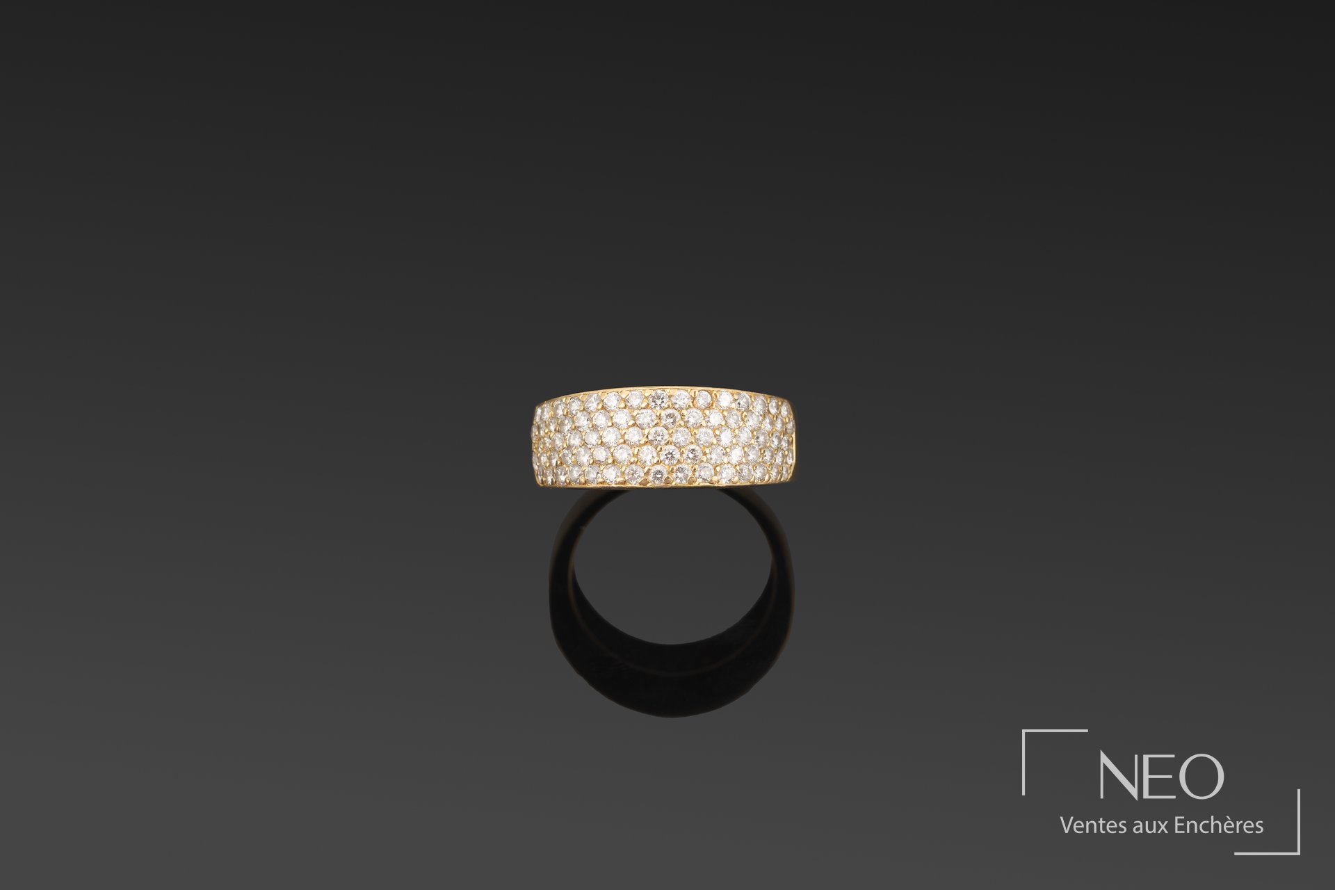 Large bague jonc en or jaune pavée de diamants sur fond sombre