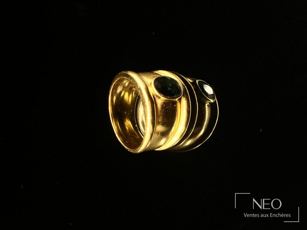 Bague jonc en or jaune avec pierre bleue ovale sur fond noir