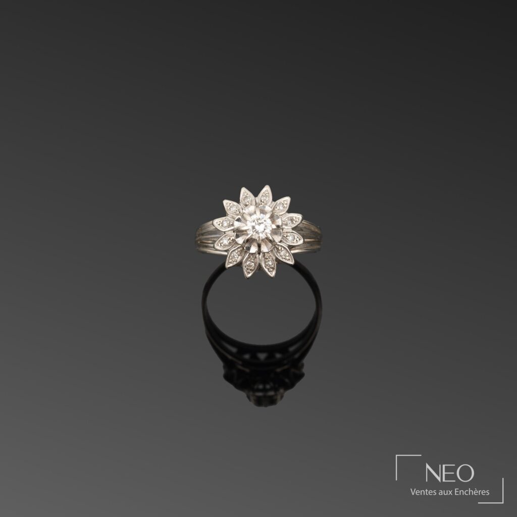 Bague marguerite en or gris avec diamant central et pétales pavés de brisures de diamant