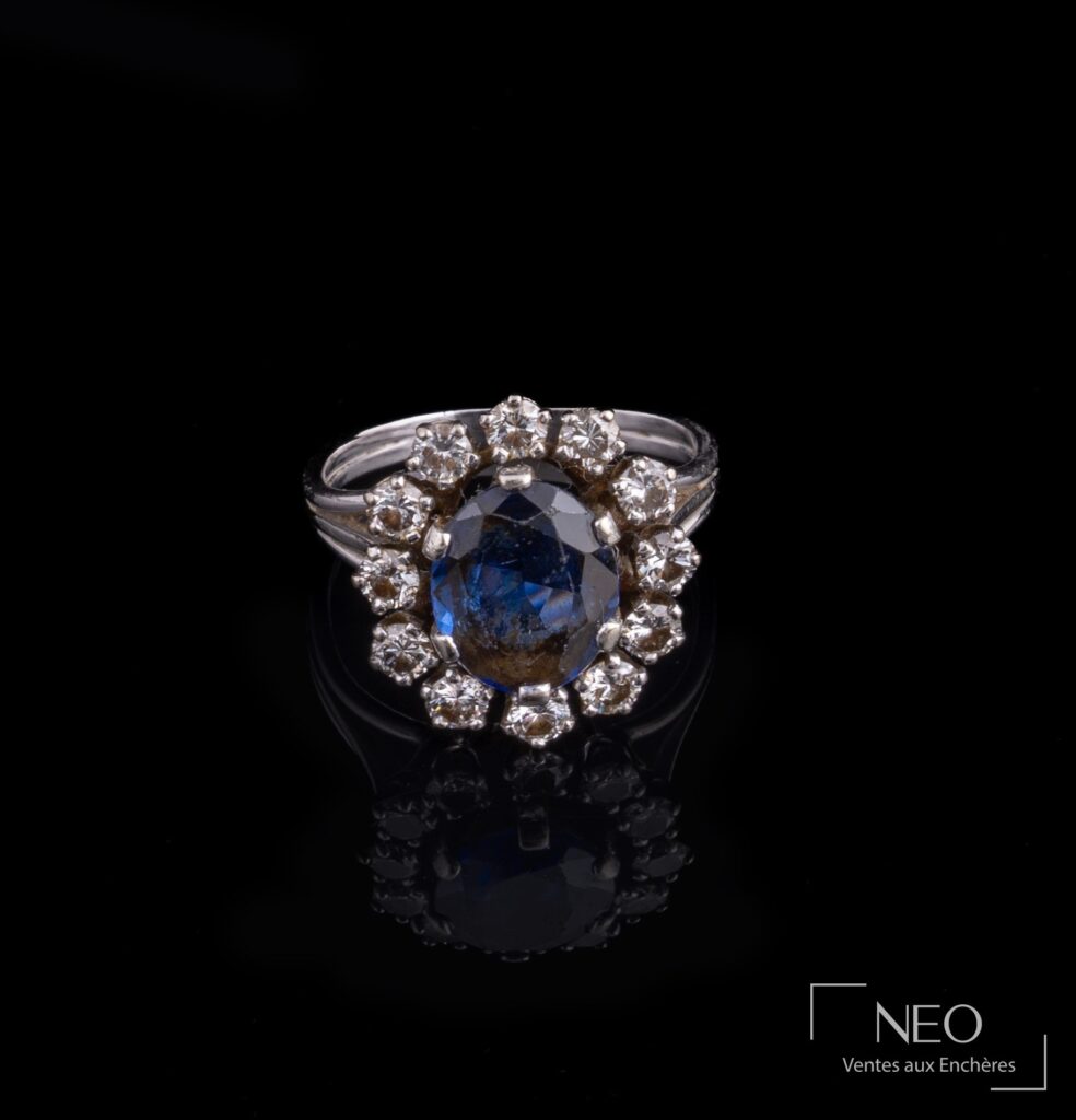 Bague marguerite en or gris avec pierre bleue centrale et entourage de diamants