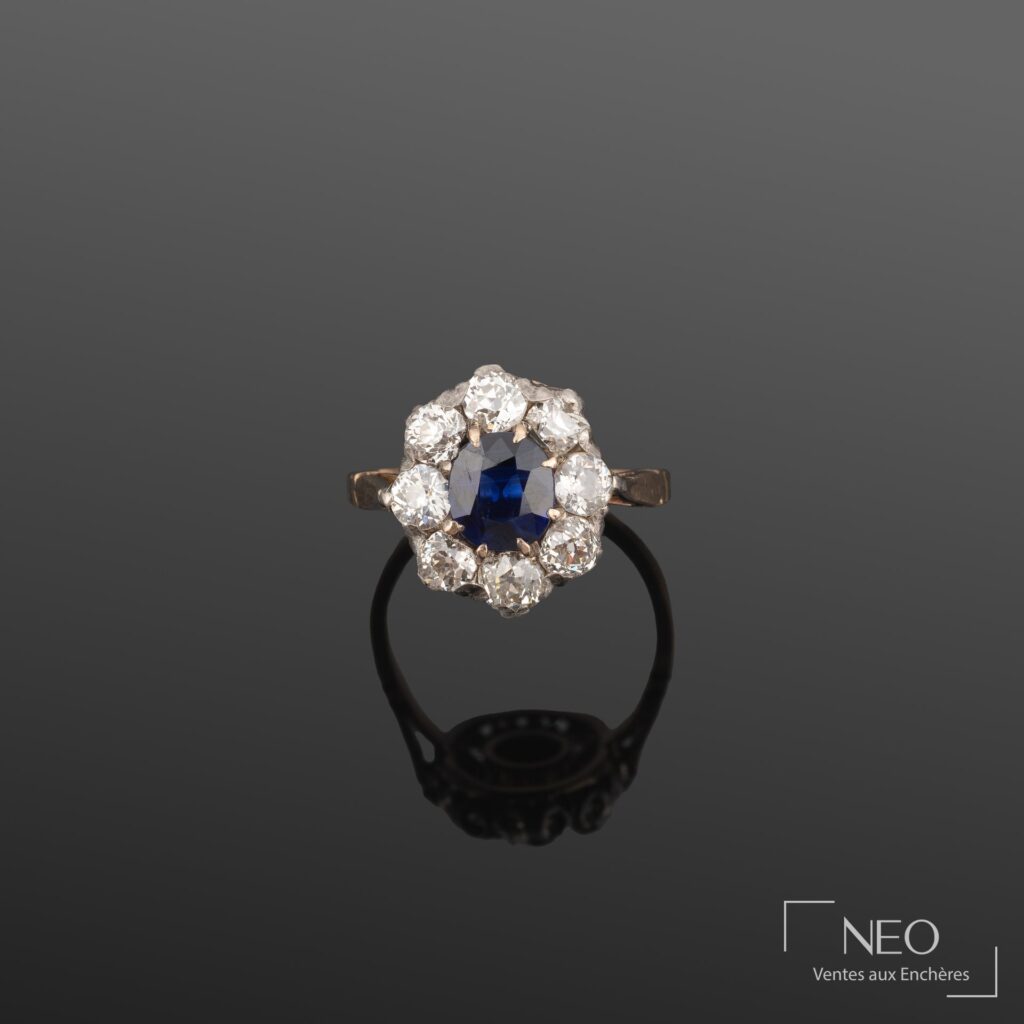 Bague marguerite en or jaune et argent sertie d'un saphir ovale entouré de diamants