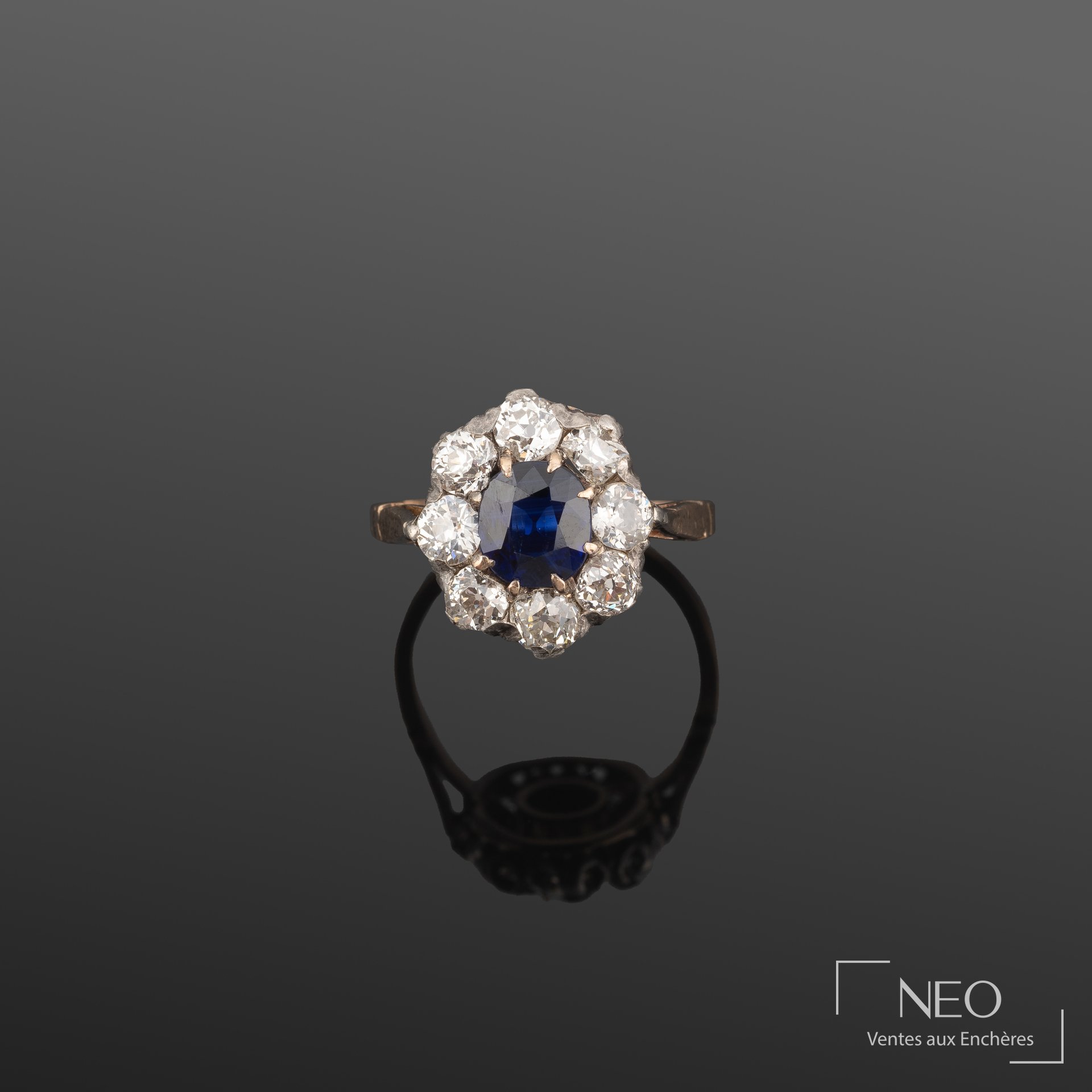 Bague marguerite en or jaune et argent sertie d'un saphir ovale entouré de diamants
