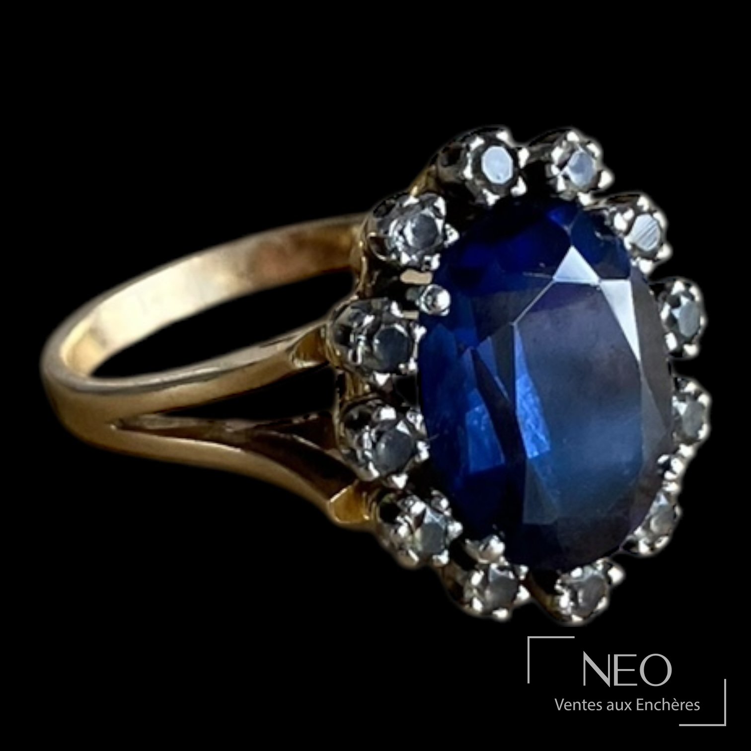 Bague marquise en or jaune avec saphir synthétique ovale et entourage de pierres blanches