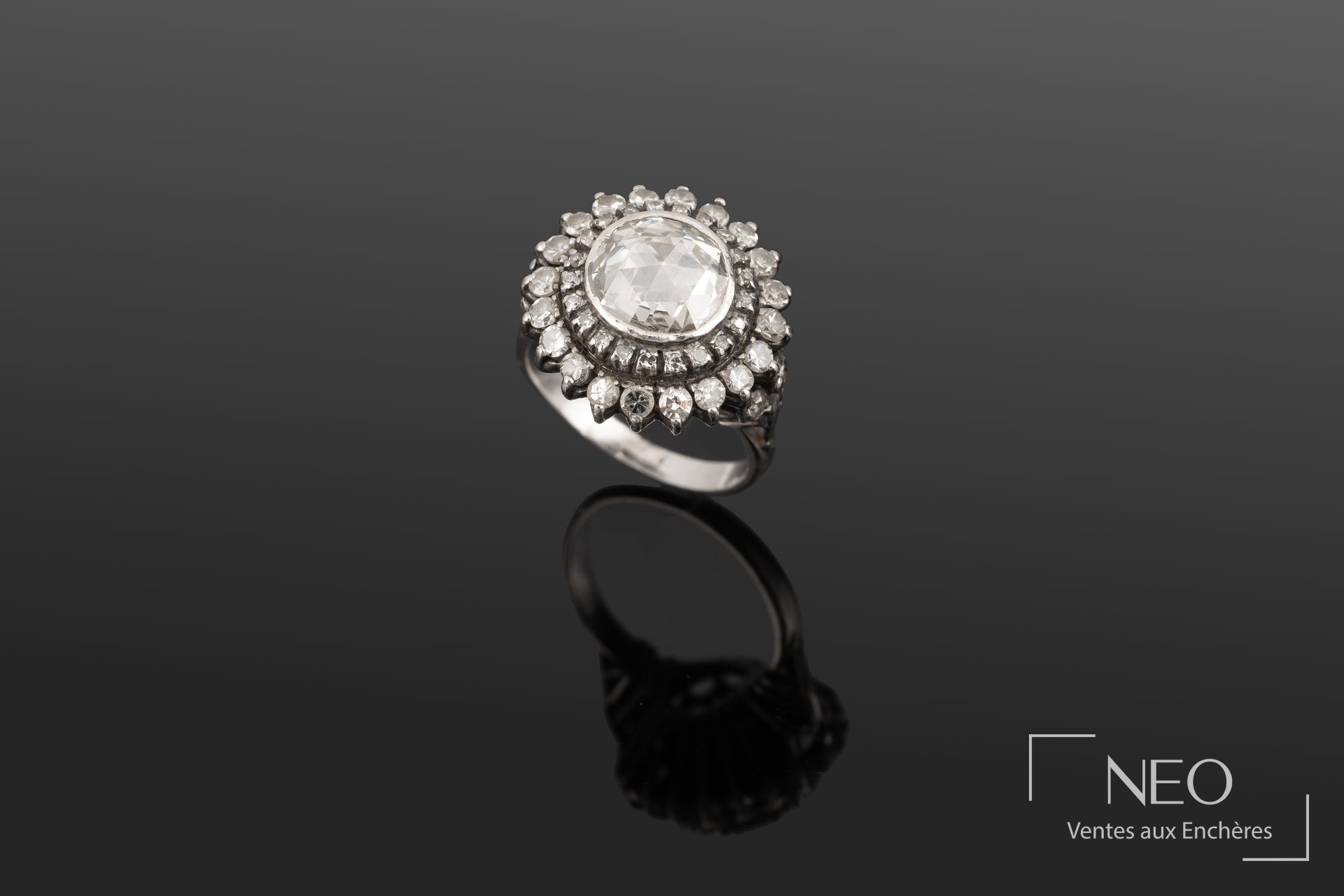 Bague en or blanc sertie d'un diamant central entouré de diamants brillants