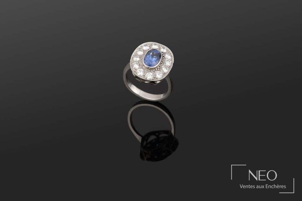 Bague en or blanc sertie d’un saphir ovale entouré de brillants