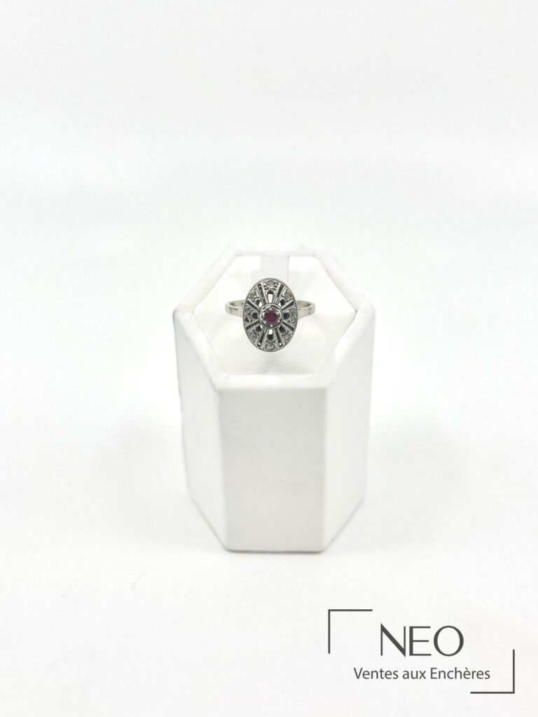 Bague ovale ajourée en or gris avec un rubis central et des diamants