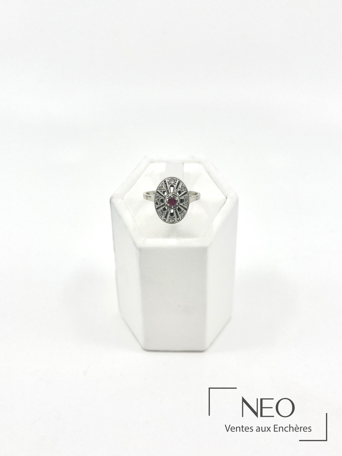Bague ovale ajourée en or gris avec un rubis central et des diamants