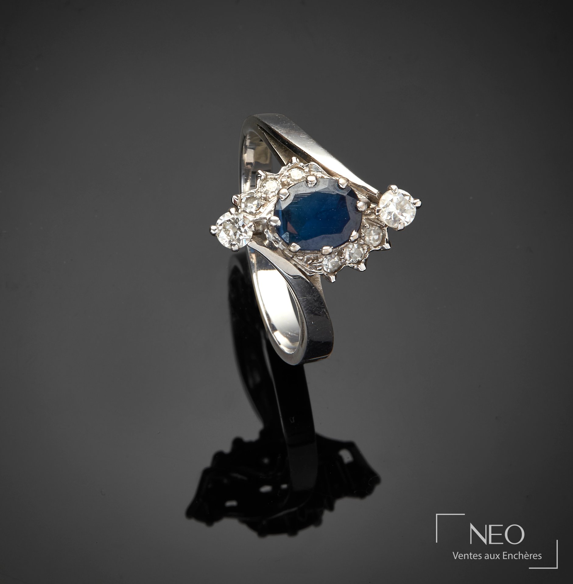 Bague en or gris 18 carats, pierre bleue et entourage de pierres blanches