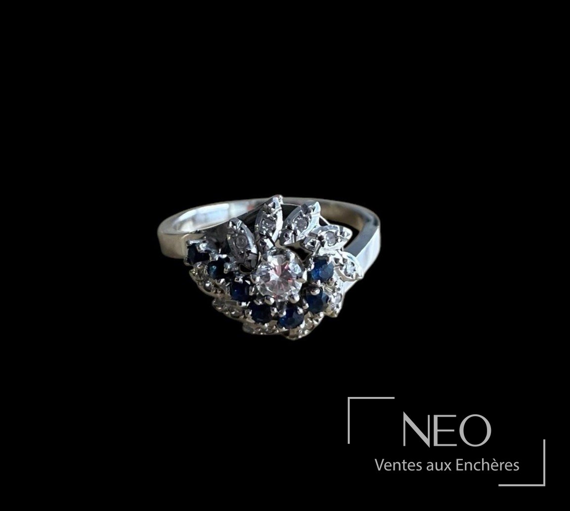 Bague en or gris sertie d’un diamant central et de pierres bleues et blanches