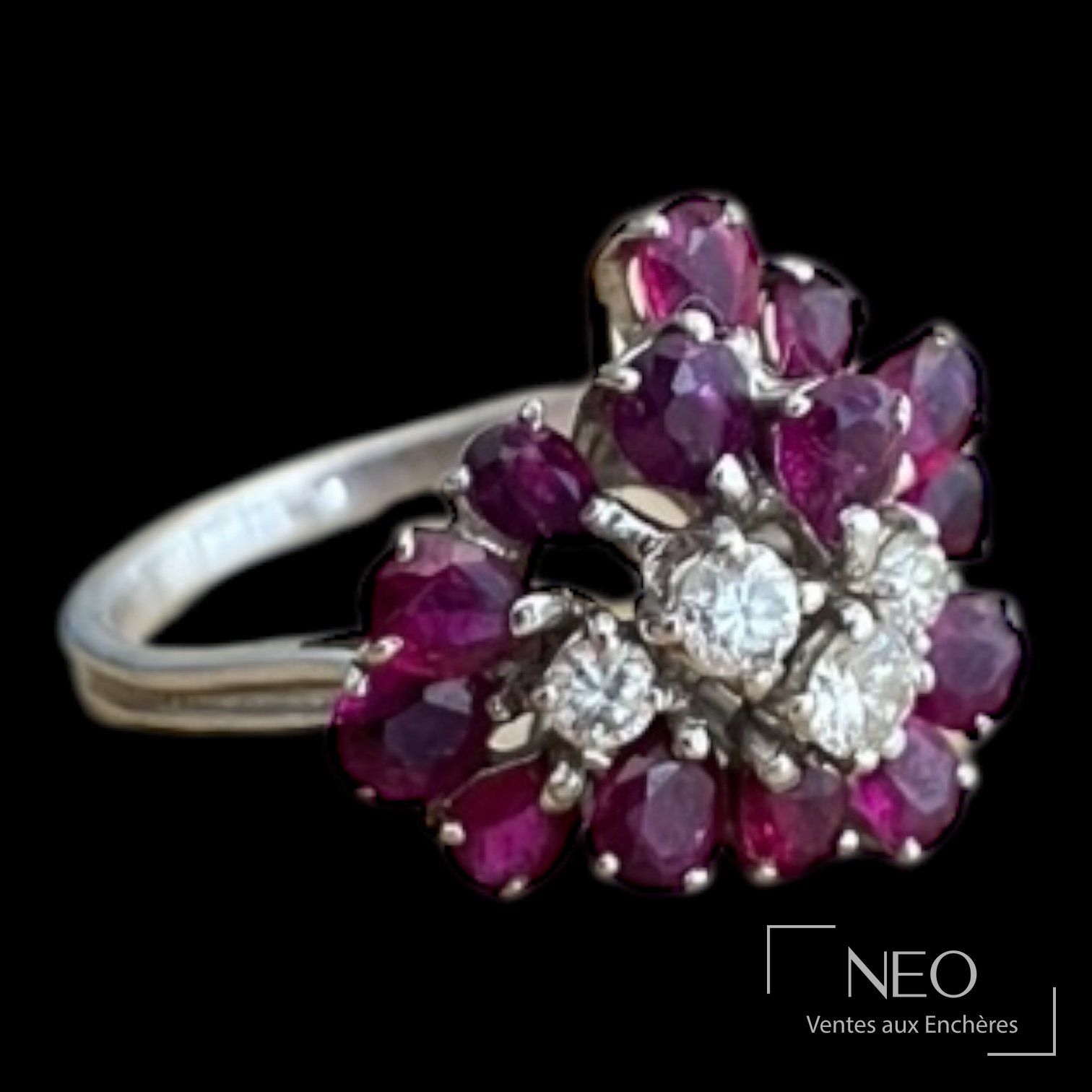 Bague en or gris sertie de grenats en bouquet et de petits diamants sur fond noir