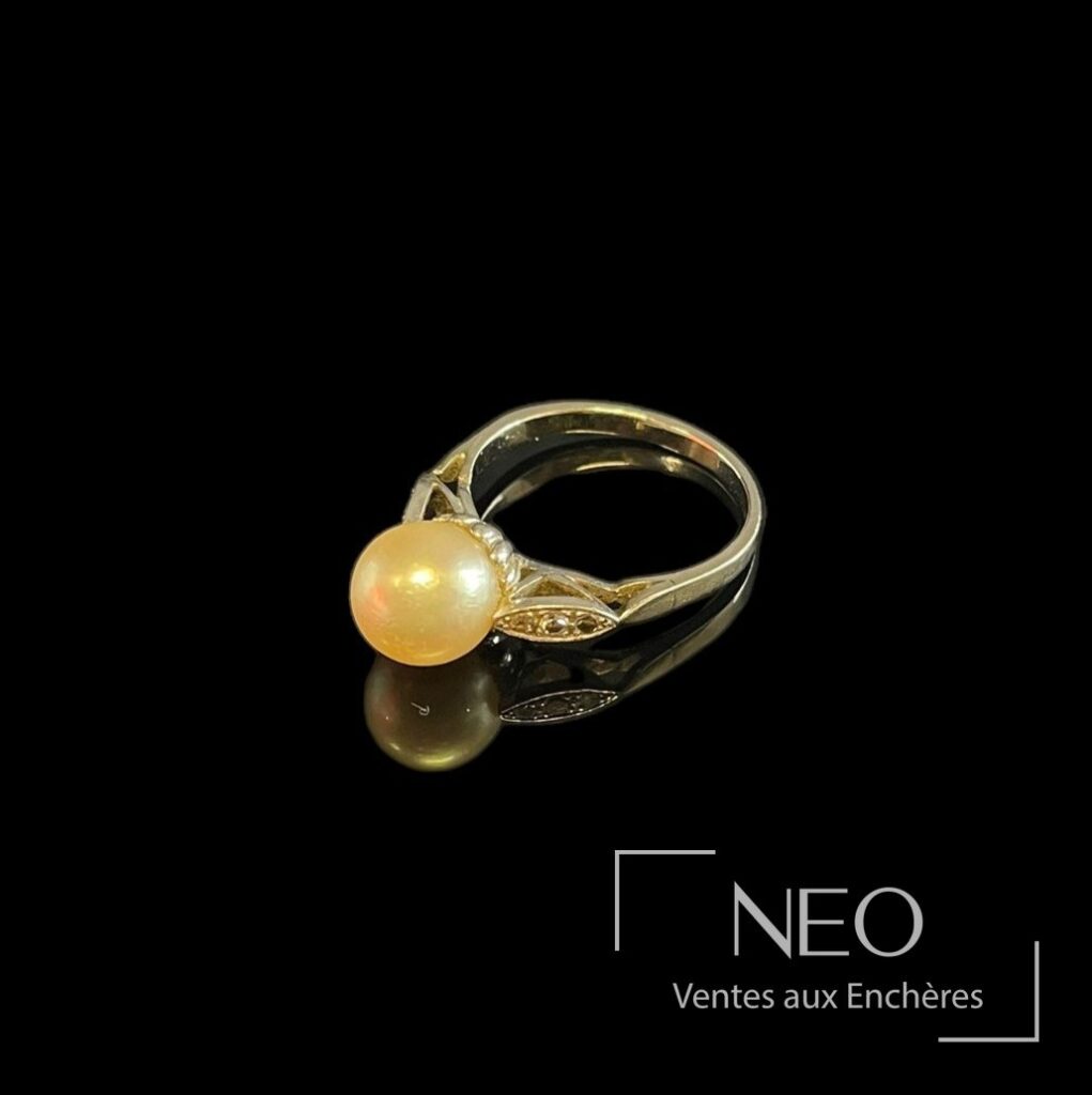 Bague en or gris avec perle de culture blanche et diamants sur fond noir