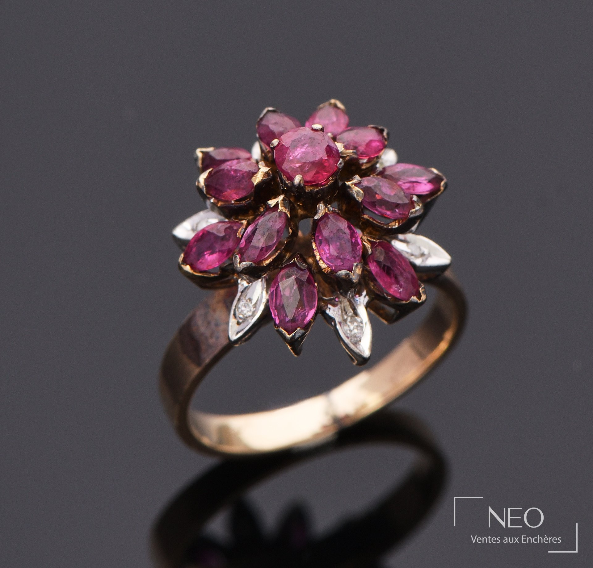Bague florale en or jaune sertie de grenats et de diamants sur fond sombre
