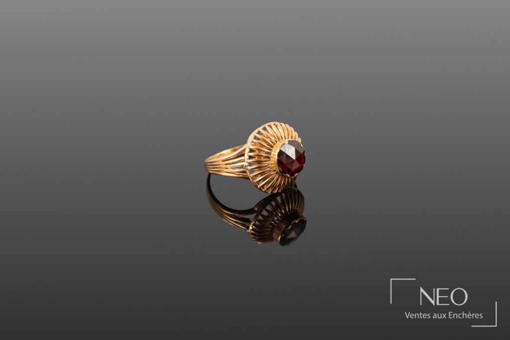 Bague en or jaune ornée d'une pierre rouge vue de face