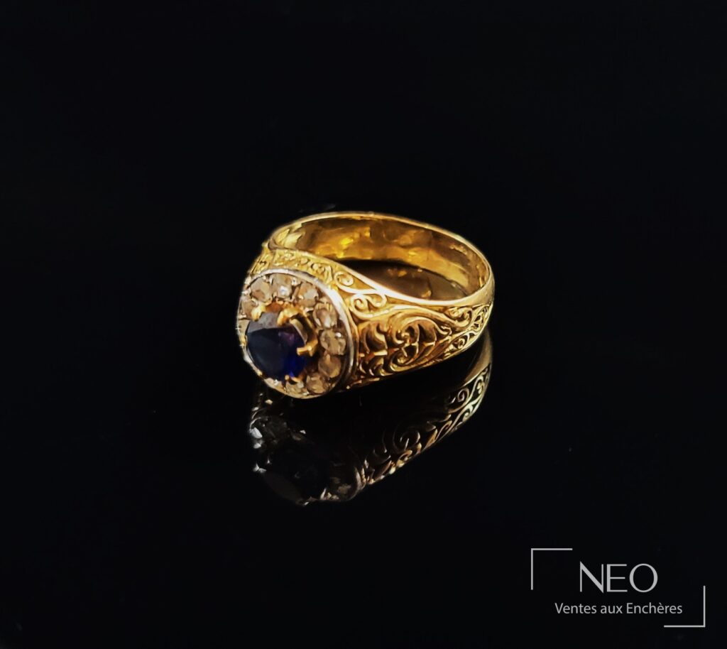 Bague en or jaune avec saphir synthétique central et entourage de diamants