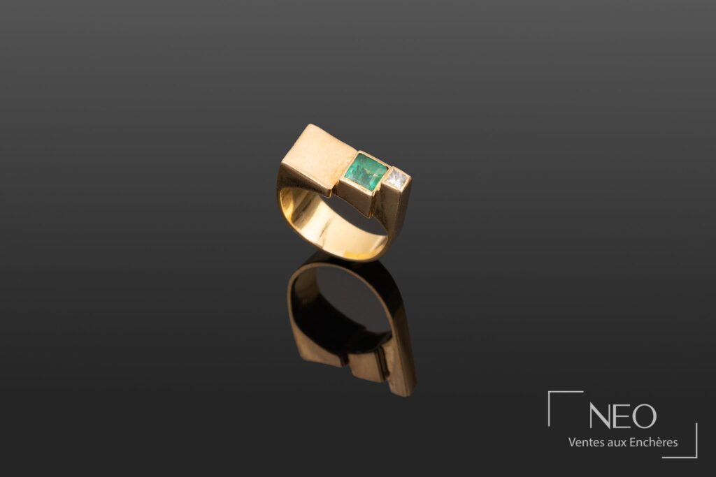 Bague en or jaune avec pierre verte et petit diamant sur plateau étagé