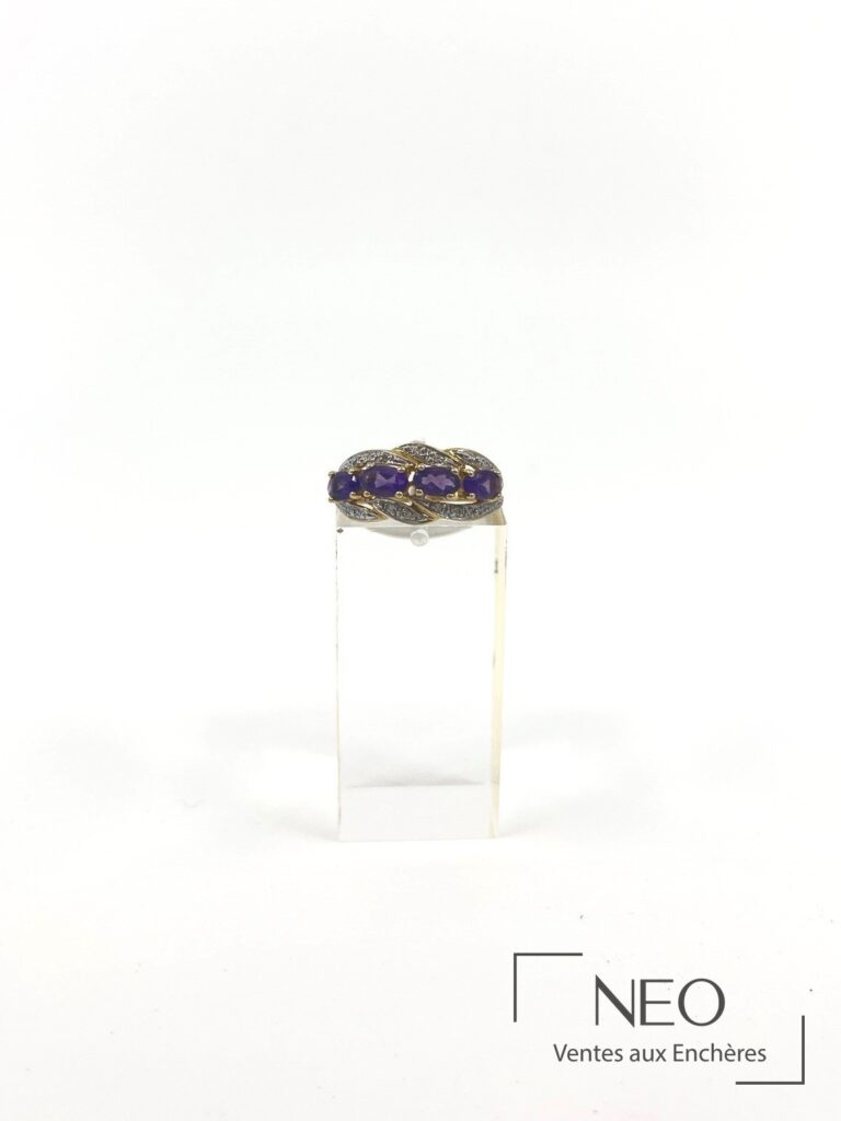 Bague en or jaune sertie de quatre améthystes et de diamants sur support transparent