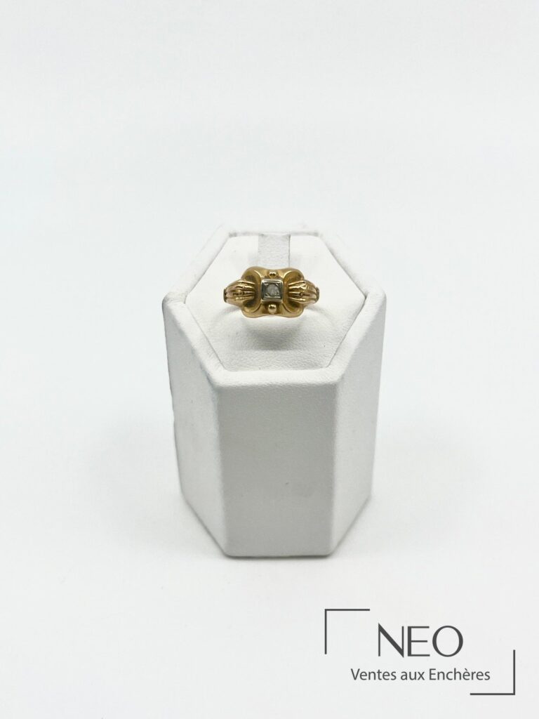Bague en or jaune de style Art Déco avec pierre blanche centrale sur présentoir