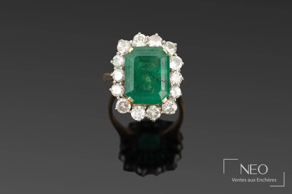 Bague en or jaune et or blanc sertie d'une émeraude rectangulaire entourée de diamants