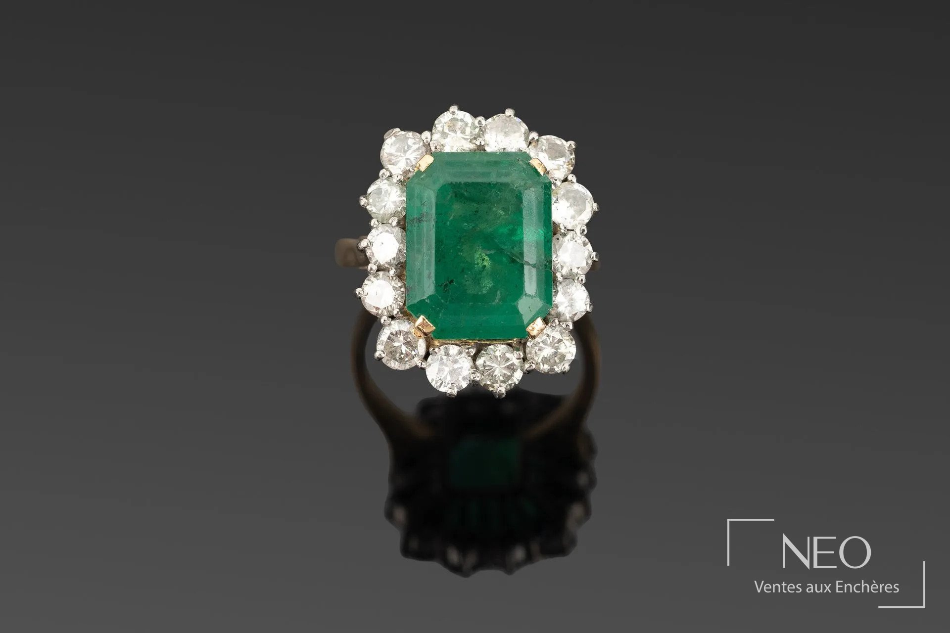 Bague en or jaune et or blanc sertie d'une émeraude rectangulaire entourée de diamants